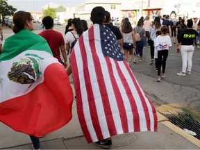 People with the Mexican flag and the U.S. flag take part in a rally against hate a day after a mass shooting at a Walmart store, in El Paso, Texas, U.S. August 4, 2019. REUTERS/Jose Luis Gonzalez
