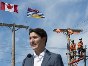 B.C. Hydro workers look on as Prime Minister Justin Trudeau makes an announcement at BC Hydro Trades Training Centre in Surrey, B.C., Thursday, August, 29, 2019.