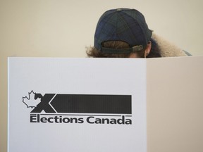 In this file photo, a voter marks a ballot behind a privacy barrier in the riding of Vaudreuil-Soulanges, west of Montreal, on election day, Monday, Oct. 19, 2015. Refugees in 2015, Syrians are now citizens in time to vote in the 2019 federal election.