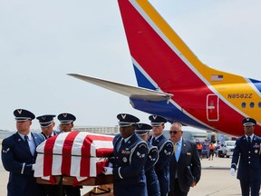 The casket with the remains of Roy Knight Jr. is carried at the Dallas Lovefield airport.