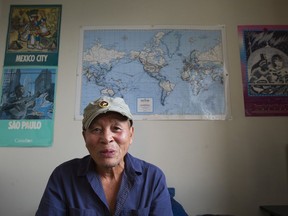 Duc Nguyen in front of a map showing his world travels.