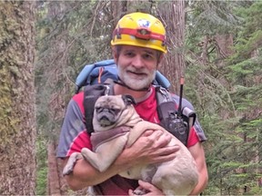 Dr. Alec Ritchie with the North Shore Search and Rescue is pictured carrying the tired pug (one of two dogs) belonging to a hiker who was lost on Mount Seymour on Sunday, Sept. 1, 2019.