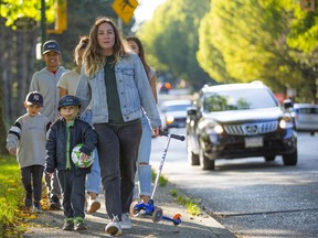 Kate Walker and her son Jules walk near Strathcona Park, where the high volume of vehicle traffic makes just walking on the sidewalk a dangerous proposition. Photo: Francis Georgian/Postmedia