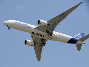 Airbus's A350 plane flies over Toulouse-Blagnac airport prior to landing at the end of its first test flight on June 14, 2013.