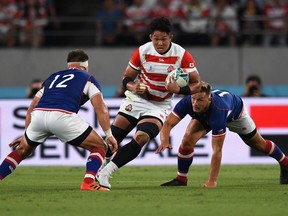 Japan's number 8 Kazuki Himeno (C) runs with the ball past Russia's centre Dmitry Gerasimov (L) during the Japan 2019 Rugby World Cup Pool A match between Japan and Russia at the Tokyo Stadium in Tokyo on September 20, 2019.