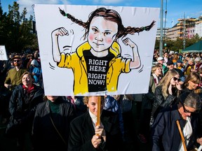 An activist holds up placard depicting the 16-year-old Swedish climate activist Greta Thunberg during "Fridays for future" demonstration, a worldwide climate strike against governmental inaction towards climate breakdown and environmental pollution in Stockholm on September 27, 2019.