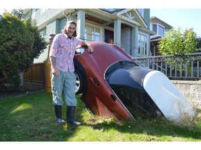 Andrew Huggard with a Mini-Cooper that he's installed as a sculpture in the front yard of his house in East Vancouver.