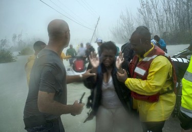 Volunteers rescue several families that arrived on small boats, from the rising waters of Hurricane Dorian, near the Causarina bridge in Freeport, Grand Bahama, Bahamas, Tuesday, Sept. 3, 2019. The storm's punishing winds and muddy brown floodwaters devastated thousands of homes, crippled hospitals and trapped people in attics.