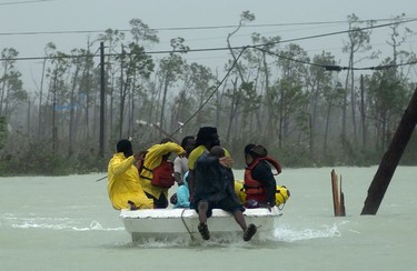 Volunteers rescue a family from the rising waters of Hurricane Dorian, near the Causarina bridge in Freeport, Grand Bahama, Bahamas, Tuesday, Sept. 3, 2019. The storm's punishing winds and muddy brown floodwaters devastated thousands of homes, crippled hospitals and trapped people in attics.