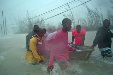 Volunteers rescue several families from the rising waters of Hurricane Dorian, near the Causarina bridge in Freeport, Grand Bahama, Bahamas, Tuesday, Sept. 3, 2019. The storm's punishing winds and muddy brown floodwaters devastated thousands of homes, crippled hospitals and trapped people in attics.