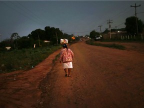 A woman walks on a dirt street during prolonged drought conditions in San Miguel, Bolivia, September 26, 2019.