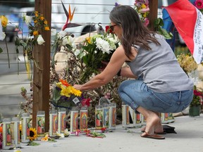 A woman places flowers at a makeshift memorial near Truth Aquatics as the search continues for those missing in a pre-dawn fire that sank a commercial diving boat near Santa Barbara, California, U.S., Sept. 3, 2019.