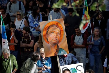 Protesters hold a placard depicting Swedish climate activist Greta Thunberg as they take part in the Fridays for Future climate change action protest in Paris, France, September 20, 2019.