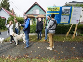 From left, Grandview-Woodland residents John Richards, Anne Worrall, Danielle Pepin, Ella Worrall, Bruce Worrall, Witmar Abelle holding Cooper, Rob Fisher, Doug Remington and Matt Crane of Hayden Crane have concerns regarding a proposed six-storey rental building in the 1500-block of Grant, in Vancouver on Sept. 15.