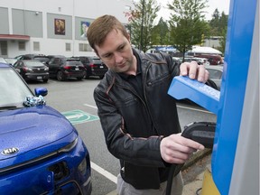 Byron Heslop replaces the charger from an EV station at Hillcrest Aquatic centre after charging his 2020 Kai Soul EV in preparation for a trip to Whistler, Vancouver May 25 2019.