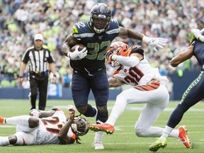 Seattle Seahawks running back Chris Carson (32) breaks away from Cincinnati Bengals defenders on his way to a touchdown during the first half at CenturyLink Field.