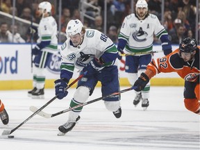 Adam Gaudette of the Vancouver Canucks powers past Tomas Jurco of the Oilers during NHL pre-season action Thursday night in Edmonton.