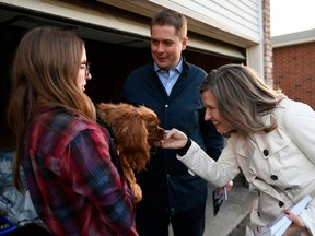 Conservative leader Andrew Scheer and Kanata Carleton candidate Justina McCaffrey meet Nicky J and her dog Louis during a door knocking event in the Kanata suburb of Ottawa on Thursday, April 25, 2019.