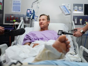 This handout photo received from Princess Alexandra Hospital in Brisbane on September 18, 2019 shows Neil Parker, 54, an Australian bushwalker talking to the media from his hospital bed.
