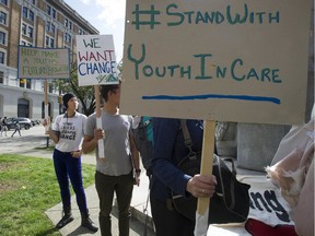 Anita Shen, left, a former youth in care, attends a rally for youth in care at Victory Square in Vancouver on Saturday.