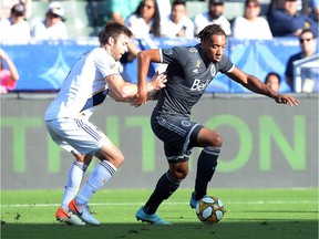 Vancouver Whitecaps forward Theo Bair (50) moves the ball ahead of Los Angeles Galaxy defender Dave Romney (4) during the first half at StubHub Center.
