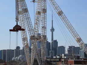 Toronto’s downtown skyline and CN Tower are seen past cranes in the waterfront area.