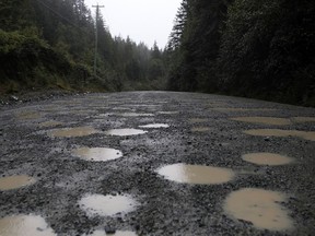 Dodging potholes is common along the Bamfield Main that leads to Bamfield, B.C. on Saturday, Sept. 14, 2019. British Columbia Premier John Horgan is expected to meet with Indigenous leaders on Vancouver Island next week to discuss the state of a treacherous logging road where two students died in a bus crash.