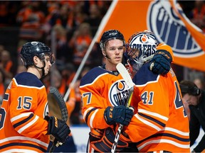 Josh Archibald, Connor McDavid and goalie Mike Smith of the Oilers celebrate their win over the Vancouver Canucks at Rogers Place on Oct. 2 in Edmonton
