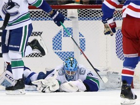 NEW YORK, NEW YORK - OCTOBER 20: Jacob Markstrom #25 of the Vancouver Canucks smothers the puck during the first period against the New York Rangers at Madison Square Garden on October 20, 2019 in New York City.