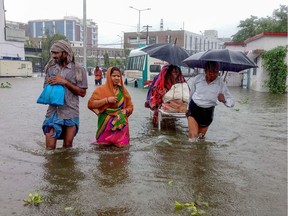 Patients wade through floodwaters on their way to hospital during heavy monsoon rain in Patna in the northeastern state of Bihar on September 28, 2019.