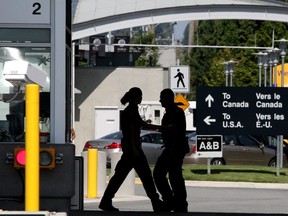 Canadian border guards are silhouetted as they replace each other at an inspection booth at the Douglas border crossing on the Canada-USA border in Surrey, B.C., on Thursday August 20, 2009. One year after pot became legal in Canada, it's still a tricky issue to cross the U.S. border where marijuana is not legal federally.