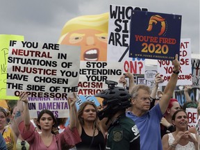 Protesters hold up anti-Trump signs during a rally earlier this year in Orlando. A large group of protesters were holding a rally near where President Donald Trump was announcing his re-election campaign.
