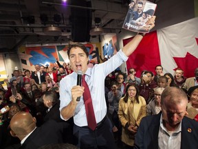 Federal Liberal leader Justin Trudeau holds up the party platform at a rally in Ottawa on Friday October 11, 2019.