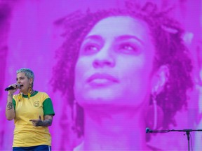 A picture of late Brazilian politician, feminist, and human rights activist Marielle Franco is projected on a screen as Juliana Strassacapa, singer of the Brazilian band 'Francisco, El Hombre' sings during their joint-performance with the Colombian band 'Monsieur Perine' at the Rock in Rio festival at the Olympic Park, Rio de Janeiro, Brazil, on October 03, 2019.