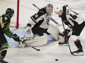 Vancouver Giants star defenceman Bowen Byram tries to clear the puck away from netminder Davis Tendeck during the WHL Championship series.
