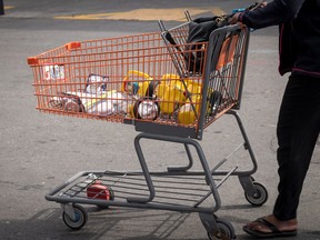 A customer pushes a shopping cart with batteries and flashlights in a Home Depot Inc. parking lot in Emeryville, California, on Tuesday getting ready for the blackout.