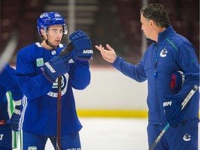Rookie defenceman Quinn Hughes receives instruction from head coach Travis Green during a Vancouver Canucks practice at Rogers Arena on Oct. 1.