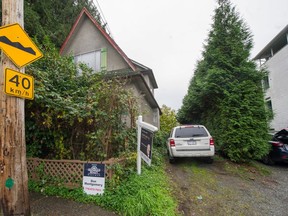 The tiny lot for sale is just wide enough to park this white Ford Escape. It is beside a house which is also for sale on Williams street just east of Victoria Drive in Vancouver.