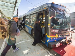 Passengers board buses on Commercial Drive on Tuesday. Job action by the drivers' union could begin on Friday.