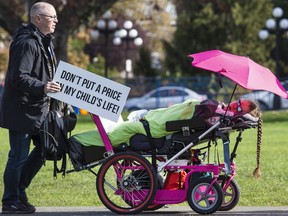 Brad Fisher and his daughter Shira Fisher, 14, who  lives with spinal muscular atrophy, make their way to the B.C. legislature for an SMA Canada Society rally.