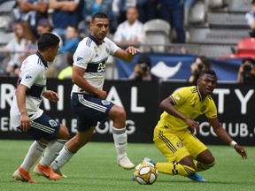 Columbus Crew midfielder Luis Diaz, right, tries to defend against Vancouver Whitecaps' Ali Adnan (53) during MLS action at BC Place Stadium on Sept. 21.