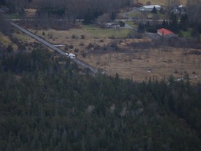 An aerial view of the plane crash scene shows police vehicles along a gravel road leading to a wooded area south of Highway 401 in Kingston, Ont. on Thursday, Nov. 27, 2019.