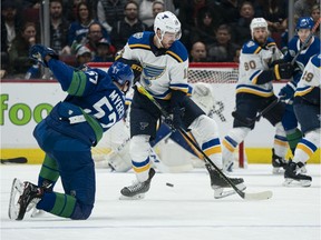 Tyler Myers of the Vancouver Canucks shoots the puck past Zach Sanford of the St. Louis Blues and on net at Rogers Arena on November 5, 2019 in Vancouver, Canada.