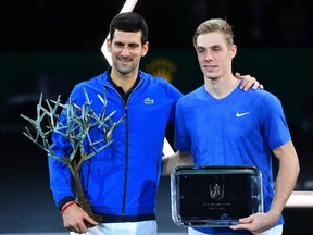 A victorious Novak Djokovic of Serbia (left) and runner-up Denis Shapovalov of Canada pose with their trophies after their men's singles final tennis match at the ATP World Tour Masters 1000 - Rolex Paris Masters - indoor tennis tournament in Paris on Nov. 3, 2019.