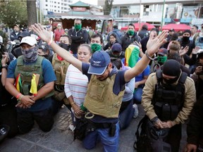 Members of the Youth Resistance "Cochala" group, who are defending against attacks from coca growers, supporters of Bolivia's resigned President Evo Morales, pray at Cala Cala square in Cochabamba, November 11, 2019. REUTERS/David Mercado