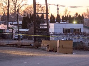 Police tape surrounds the apartment building at 170 Carson Cres., where a body was found in the alleyway behind the building on Friday morning.