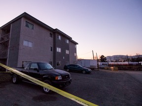 Police tape surrounds the apartment building at 170 Carson Cres., where a body was found in the alleyway behind the building on Friday morning.