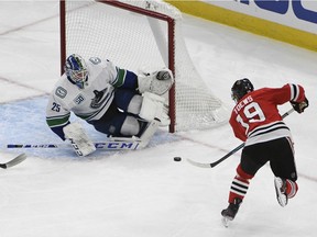 Chicago Blackhawks centre Jonathan Toews (19) shoots the puck against Vancouver Canucks goaltender Jacob Markstrom (25) during the second period at United Center. Mandatory Credit: David Banks-USA TODAY Sports