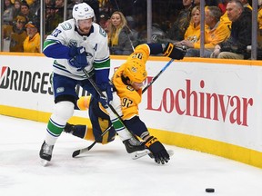 Defenceman Alex Edler of the Vancouver Canucks trips up Predators' centre Ryan Johansen during Thursday's NHL game at Bridgestone Arena in Nashville. The Canucks' play the Washington Capitals on Saturday morning.