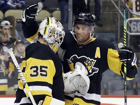Pittsburgh Penguins goaltender Tristan Jarry (35) and defenceman Brian Dumoulin (8) celebrate after defeating the Vancouver Canucks at PPG PAINTS Arena. The Penguins won 8-6.